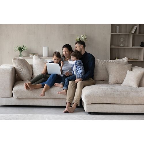 Family of four on couch watching laptop image