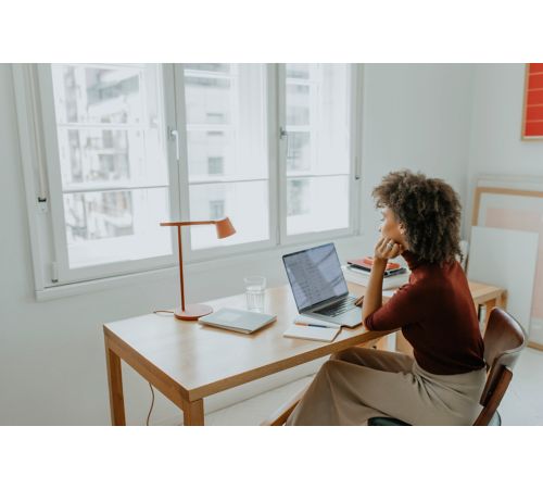 women sitting at desk looking at computer